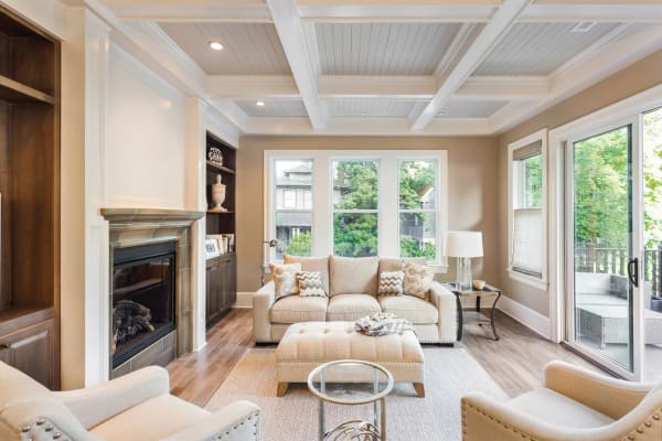 A living room with a coffered ceiling, built-in shelving and painted trim