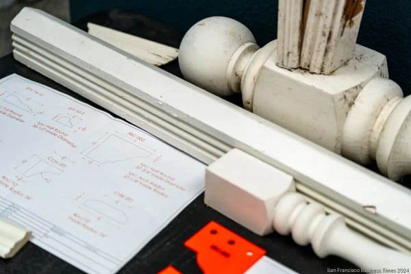 White-painted moulding samples and a turned newel beside profile drawings
